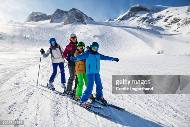 famiglia che si gode lo sci insieme al ghiacciaio nelle alpi - vacanza sulla neve foto e immagini stock