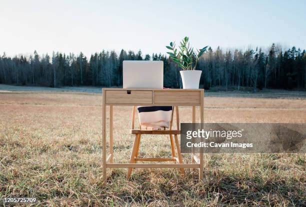 a desk and laptop home office in the middle of a field outdoors - garden office bildbanksfoton och bilder