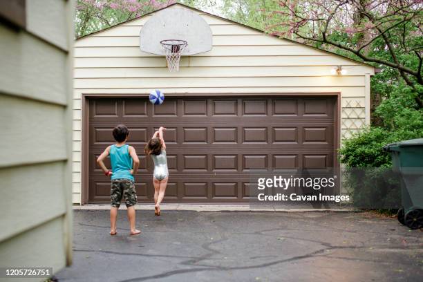 a little girl shoots a basketball while her big brother watches on - columbus ohio house stock pictures, royalty-free photos & images