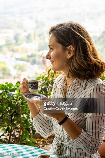 young woman enjoys a cup of turkish coffee in istanbul on vacation - turkish coffee drink stock pictures, royalty-free photos & images