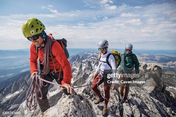 climbing guide leads two clients to the summit of the grand teton - wilderness guide stock-fotos und bilder