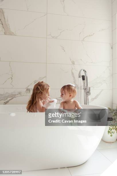 little brother and sister bathing in a foam bath - baby shower - fotografias e filmes do acervo