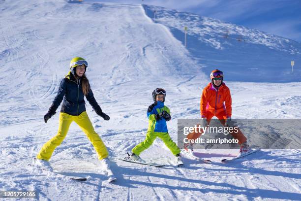 echte mensen vrouwen kind jongen genieten van ski-vakantie op helling - ploeg stockfoto's en -beelden