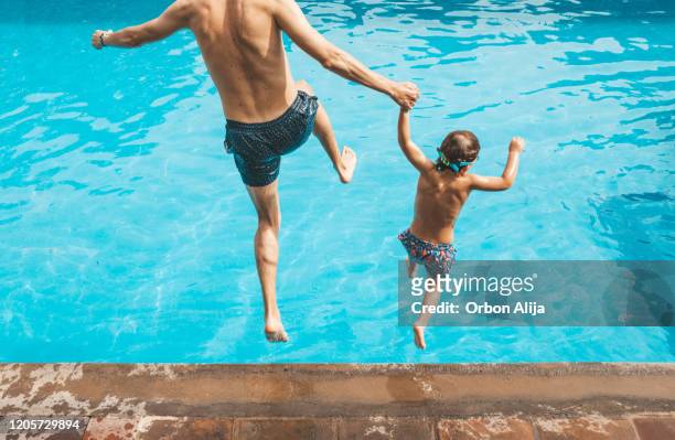 vader en zoon die pret op het zwembad hebben - jump dad stockfoto's en -beelden