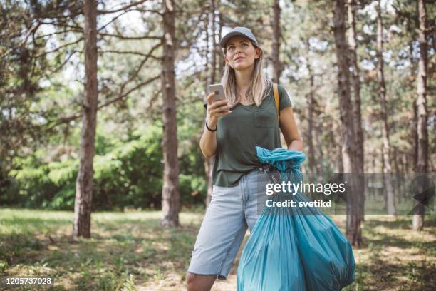 volunteer cleaning park - holding garbage bag stock pictures, royalty-free photos & images