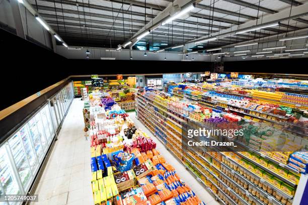 aisles and shelves in supermarket, wide angle view - food staple stock pictures, royalty-free photos & images