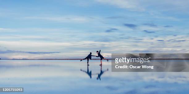 couple dancing on salt flat against sky at salar de uyuni - nature symmetry stock pictures, royalty-free photos & images