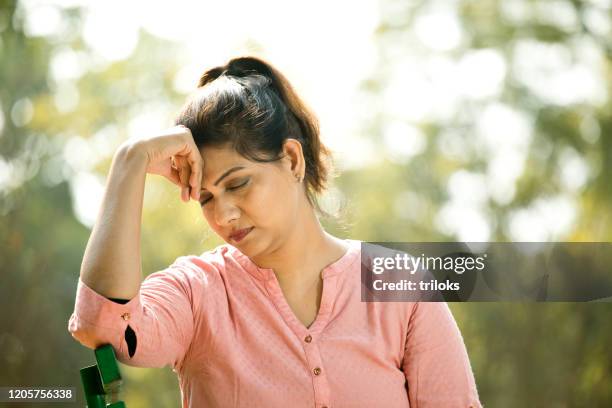 worried woman with head in hands - disappointed indian woman with head in hands stock pictures, royalty-free photos & images