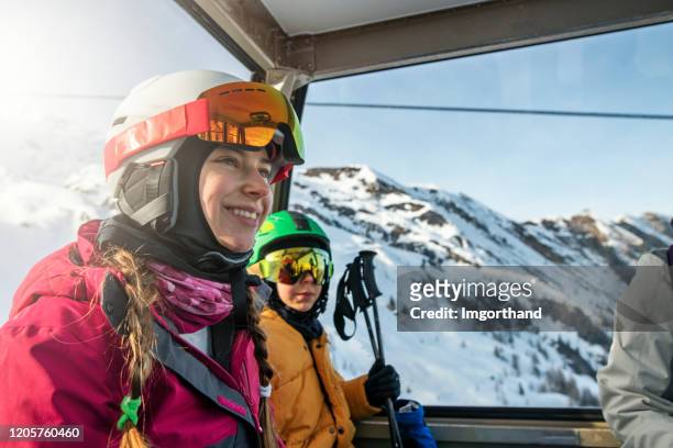 family enjoying gondola ski lift ride in alps - woman on ski lift stock pictures, royalty-free photos & images