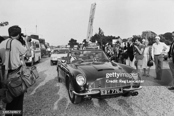 Charles, Prince of Wales driving his Aston Martin DB5 Volante Convertible sports car, with his wife, Diana, Princess of Wales in the passenger seat,...