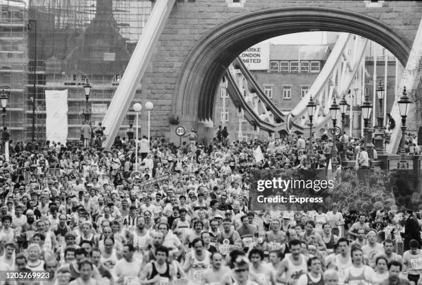 London Marathon runners crossing Tower Bridge over the River Thames in London, England, 21st April 1985.