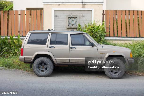 old jeep cherokee parked in street in bangkok - jeep cherokee stock pictures, royalty-free photos & images