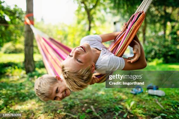 brothers playing on hammock on sunset - 8 year old play stock pictures, royalty-free photos & images