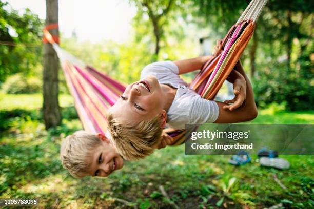 brothers playing on hammock on sunset - hammock stock pictures, royalty-free photos & images