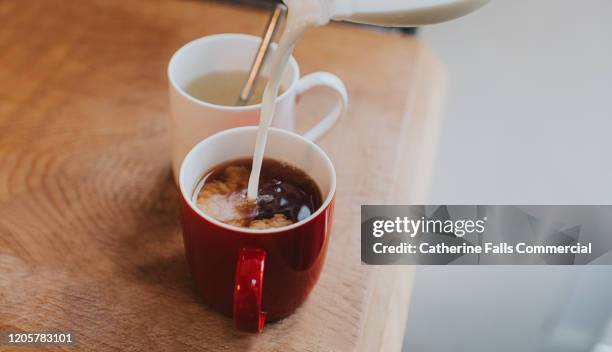 adding milk to tea - 温かい飲み物 ストックフォトと画像