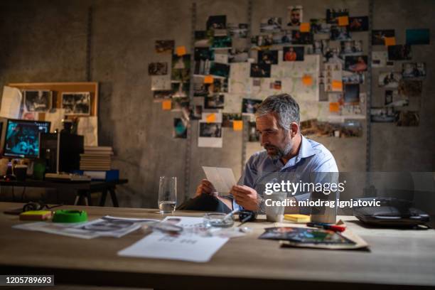 police chef working late at night in office to solve a case - detective badge stock pictures, royalty-free photos & images