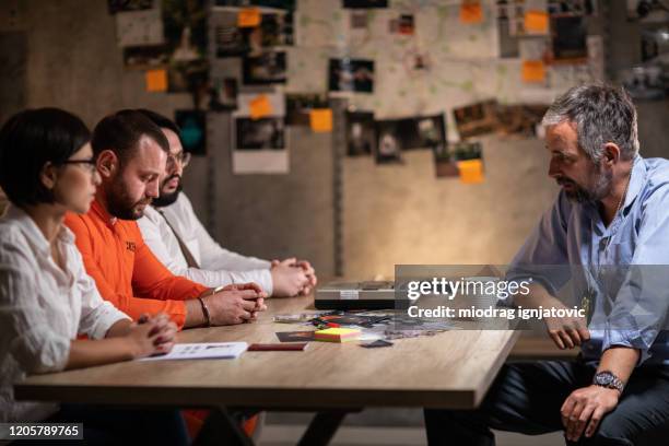 prisoner with handcuffs being interviewed in interrogation room - fbi director stock pictures, royalty-free photos & images