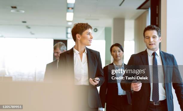 colegas que consultan en un solitario - embajador fotografías e imágenes de stock