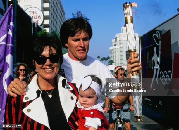 Former 1976 Olympic Decathlon gold medallist Bruce Jenner holds the Olympic Torch with Kris Jenner and daughter Kendall Jenner during the torch relay...
