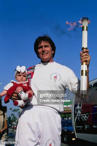 Former 1976 Olympic Decathlon gold medallist Bruce Jenner holds the Olympic Torch with daughter Kendall Jenner during the torch relay for the XXVI...