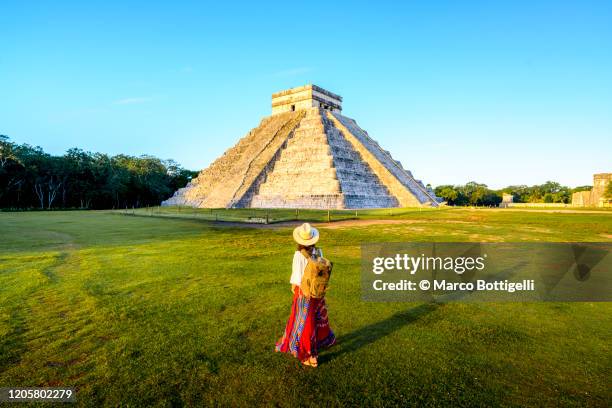 woman admiring the temple of kukulcan (el castillo) in chichen itza, yucatan, mexico - mexico stock pictures, royalty-free photos & images