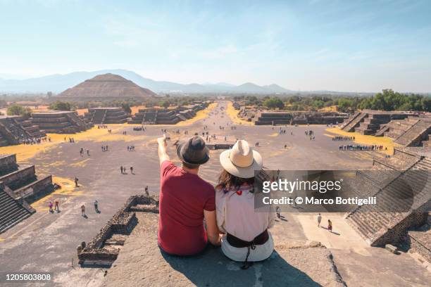 tourists couple admiring the view of teotihuacan archaeological site, mexico - astecas imagens e fotografias de stock