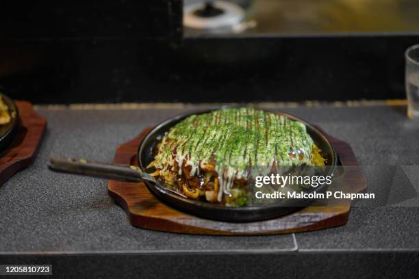 okonomiyaki served in a restaurant in nagasaki, kyushu, japan - okonomiyaki 個照片及圖片檔