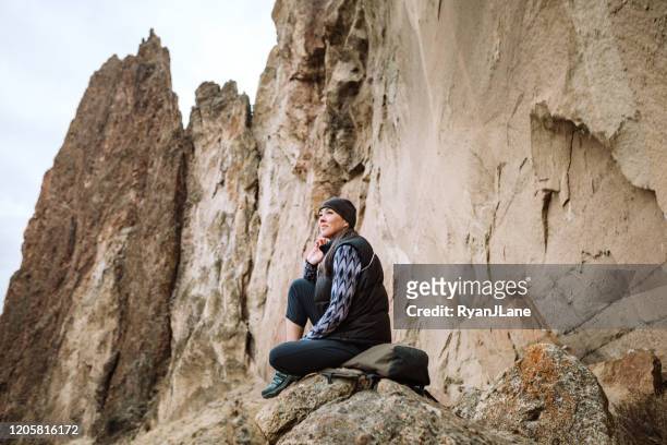 hiking mature adult woman stops to look at view - smith rock state park stock pictures, royalty-free photos & images