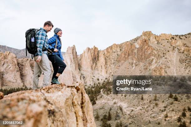 volwassen paar dat in ruw gebied wandelt - smith rock state park stockfoto's en -beelden