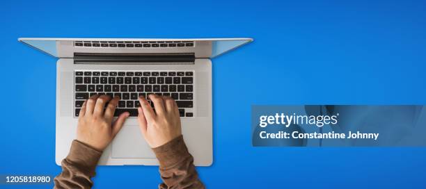 overhead view of hand using laptop over blue background - johnny stark stock pictures, royalty-free photos & images