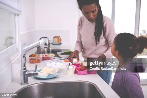 mother and daughter packing lunch. - making lunch stock pictures, royalty-free photos & images