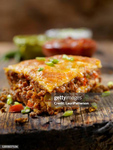 gebakken, gelaagde, beef taco pie met zure room, salsa en guacamole - savory pie stockfoto's en -beelden