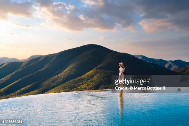 woman looking at view at hierve el agua, oaxaca, mexico - infinity pool - fotografias e filmes do acervo