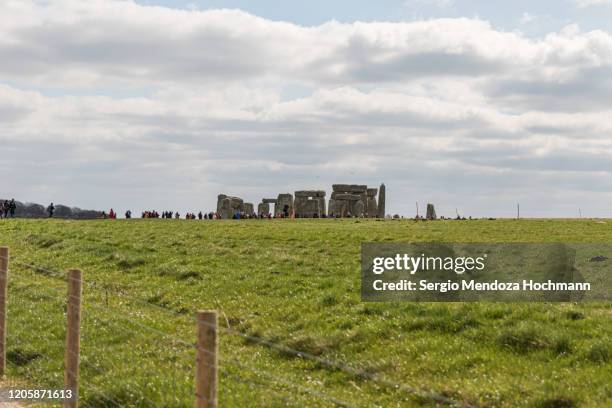 tourists visiting the stonehenge monoliths in wiltshire, united kingdom - amesbury stock pictures, royalty-free photos & images