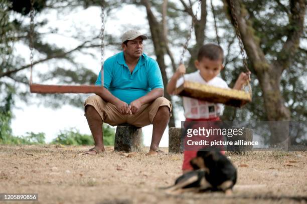 March 2020, Nicaragua, Solentiname: The local Solentiname craftsman José Francisco Peña takes care of his grandson who plays on a swing on the island...