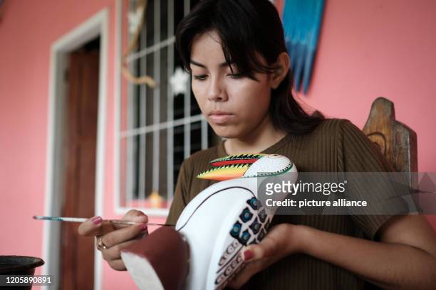 March 2020, Nicaragua, Solentiname: Olga Virgina Peña, the daughter of José Francisco Peña, paints her father's works and puts the finishing touches...
