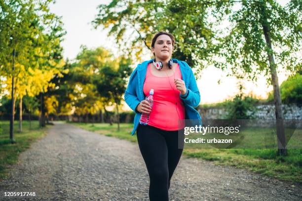 joven mujer con sobrepeso corriendo - chicas gorditas fotografías e imágenes de stock