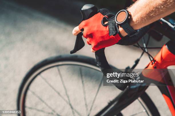 nahaufnahme radfahrer hand mit sportuhr halten lenker - cycle stock-fotos und bilder