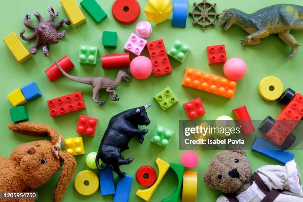 high angle view of toys over green background - juguetes fotografías e imágenes de stock