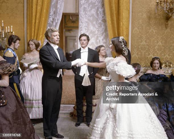 American actor Burt Lancaster inviting Italian actress Claudia Cardinale for a dance. French actor Alain Delon looking at them in a scene from the...