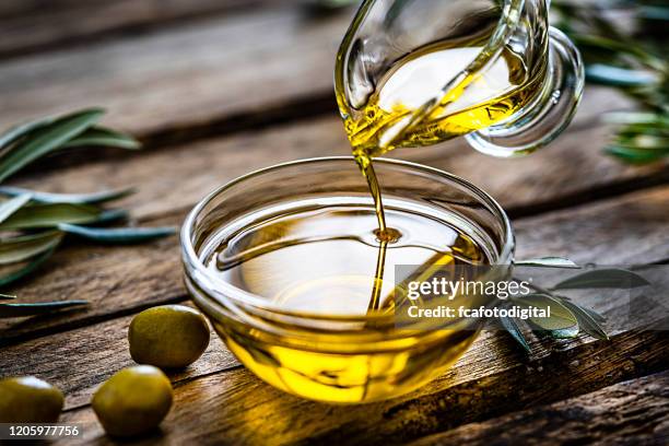 gieten extra vergine olijfolie - oil flow stockfoto's en -beelden