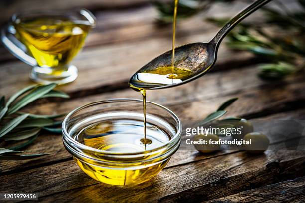 pouring extra virgin olive oil - olive oil bowl stock pictures, royalty-free photos & images