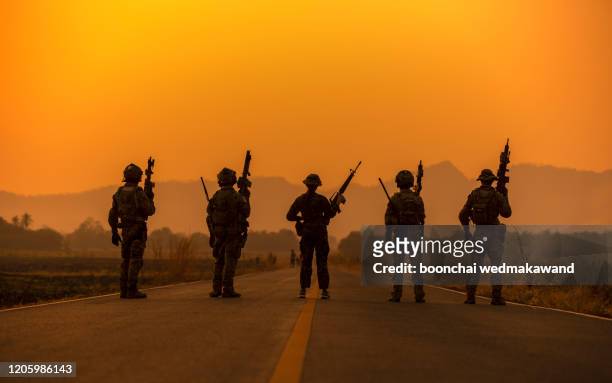 silhouette soldiers on the sunset sky background - konflikt bildbanksfoton och bilder