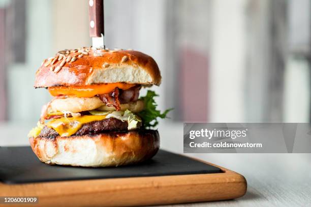 fresh flame grilled bacon cheeseburger on wooden board - pattie sellers stock pictures, royalty-free photos & images