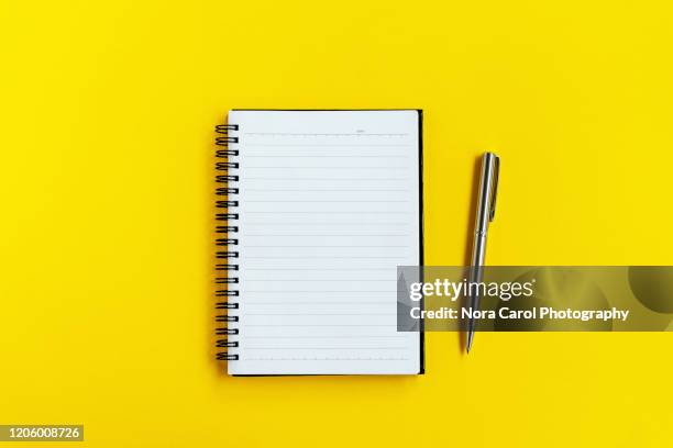 note pad and pen on yellow background - spiral notebook stock pictures, royalty-free photos & images