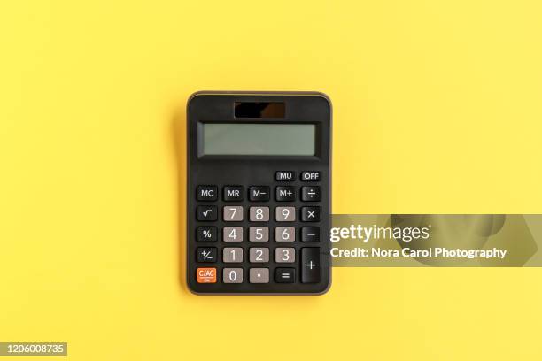 calculator on yellow background - calculadora imagens e fotografias de stock