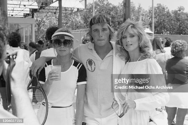 American actress and producer Donna Mills, American actor Christopher Atkins, and American actress Morgan Fairchild attend a tennis match, circa 1980.