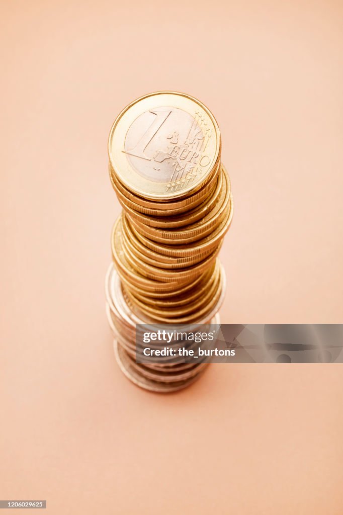 Stack of Euro coins on brown background