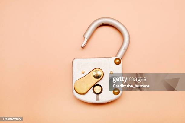 high angle view of open metal padlock on brown background - 錠前 ストックフォトと画像