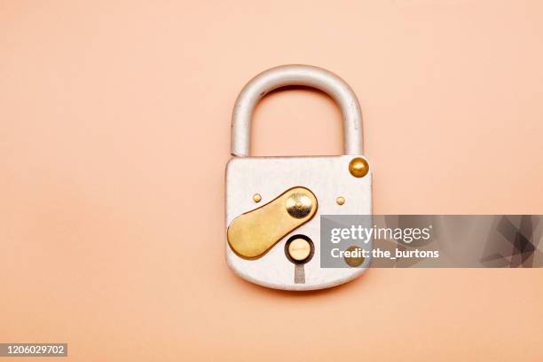 high angle view of closed metal padlock on brown background - password stock pictures, royalty-free photos & images